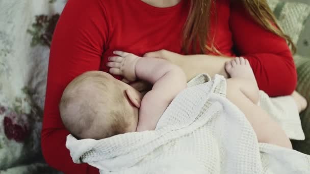 Moeder in rode jurk borstvoeding kleine baby. Moederschap. Gezondheidszorg. — Stockvideo