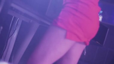 Gece kulübünde pikap dönen kırmızı mini elbiseli Dj kız. Dans. Clubbing