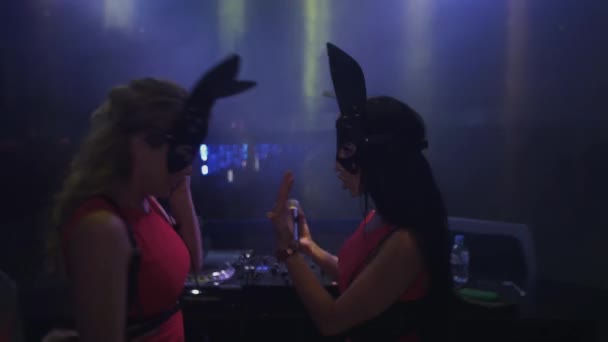 Mc girl und dj girl in Hasenmasken treten am Plattenteller im Nachtclub auf. Kopfhörer — Stockvideo