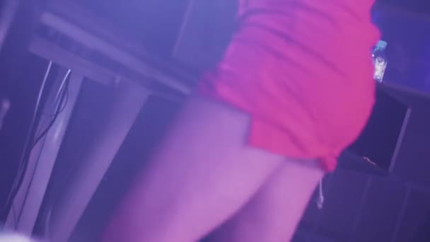 DJ Mädchen in rotem Minikleid dreht sich am Plattenteller in einem Nachtclub. Tanzen. Clubbing — Stockvideo