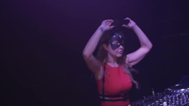 DJ flicka i hare mask, röd klänning hoppa på skivspelare i klubben. Touch öron på mask — Stockvideo