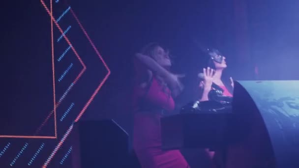 Dj girl and mc girl energy dance at turntable in club. Raise hands. Illumination — Stock Video