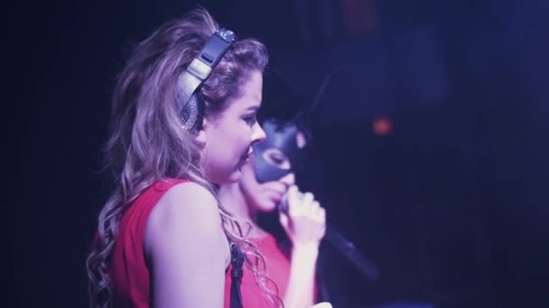 Dj chica y mc chica en máscaras de liebre girando en el tocadiscos en discoteca. Auriculares — Vídeos de Stock