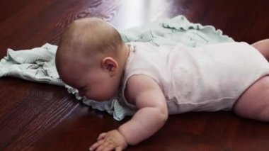 Küçük bebek yalan yere mide üzerinde. Daire. Ağlıyor. Hareketleri.