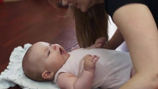 Giovane madre fare flessioni e baciare il bambino sdraiarsi sul pavimento. Appartamento. Esercizi — Video Stock
