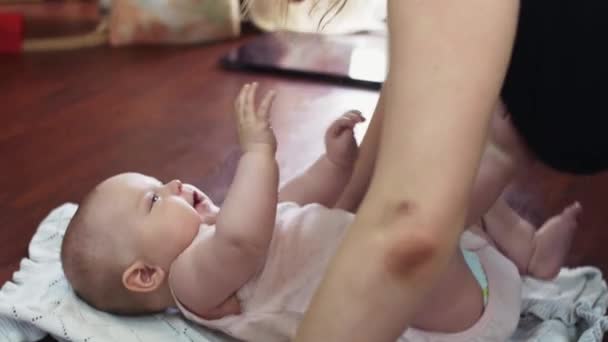 Jonge moeder maken push ups kus baby op de vloer liggen. Appartement. Geluk. — Stockvideo