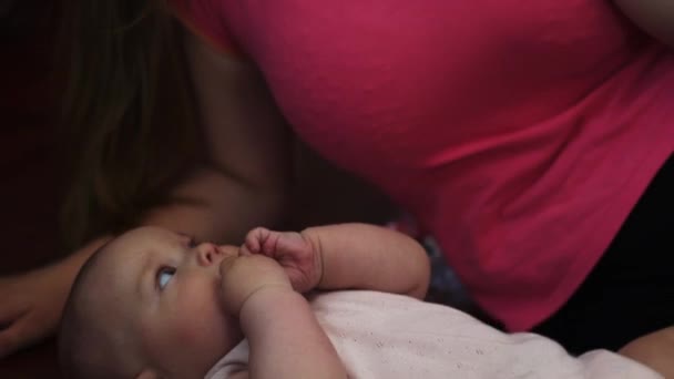 Young mother lie on floor with little crying baby, speak on phone. Apartment. — Stock Video