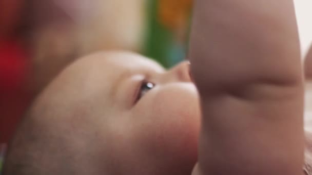 Retrato de un bebé adorable yace en la cuna jugando con juguetes. Lindo. Maternidad — Vídeo de stock