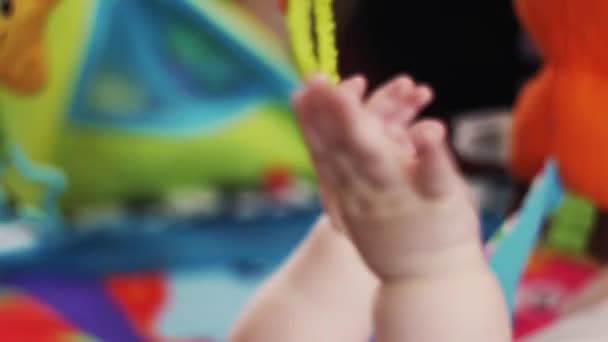 Handen van kleine baby liggen in wieg spelen met speelgoed. Cute. Moederschap. Kind — Stockvideo