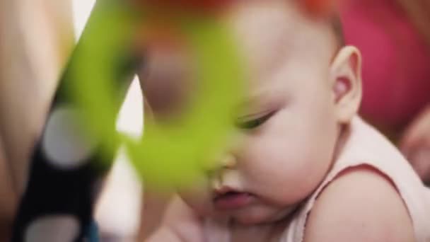 Adorable bebé en cuna jugando con juguetes de colores. Lindo. Maternidad. Niño. — Vídeo de stock
