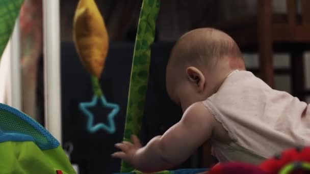 Schattige kleine baby spelen met speelgoed op kleurrijke ontwikkelen kinderen tapijt. Kind — Stockvideo