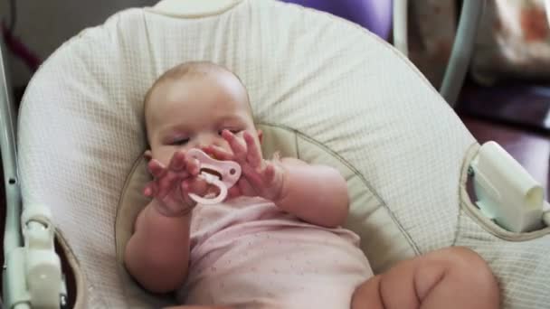 Adorabile piccolo bambino ondeggia sull'altalena in appartamento. Gioca con il pupazzo. Bambino. . — Video Stock