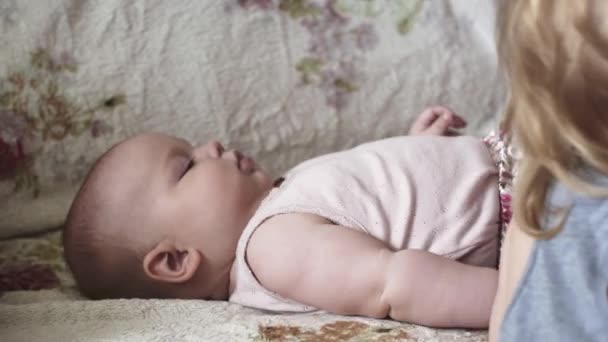 Giovane madre vestire bambino sul divano, figlio biondo. La maternità. Famiglia. Cura — Video Stock