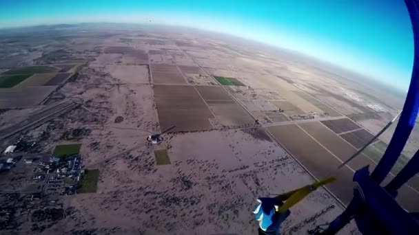 Profesyonel skydiver Arizona yukarıda mavi gökyüzünde paraşütle atlama. Sandy ülke. — Stok video