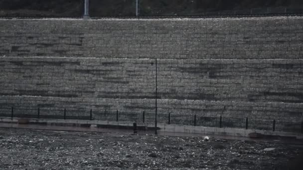 Man ride on skateboard on street under drops of rain fall on ground. Drizzle — Stock Video