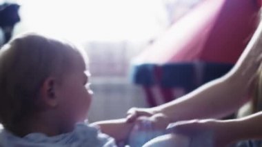 Genç anne elbise küçük oğlu kanepe üzerinde ağlayarak. Annelik. Gömlek. Çocuk