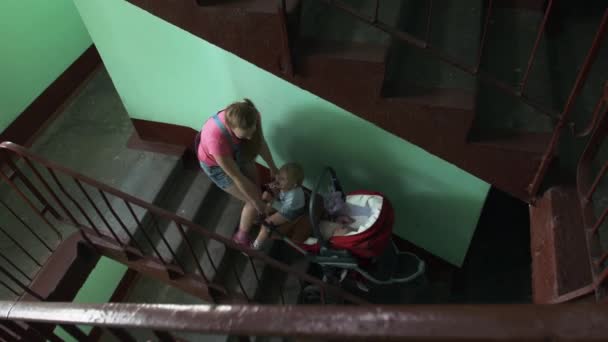 Moeder zette kinderwagen van trap. Moederschap. Jongetje in de camera kijken — Stockvideo