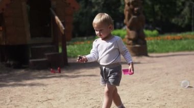 Küçük Çocuk Bahçesi üzerinde taş atmak. Kum. Güneşli bir gün. Anne. Aile.