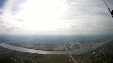 Yeşil alan üzerinde uçan paraşütçü nehir. Aşırı aktif spor. Adrenalin.