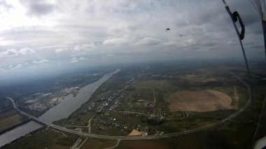 Yeşil alan üzerinde uçan paraşütçü nehir. Aşırı spor. Adrenalin. Rüzgar