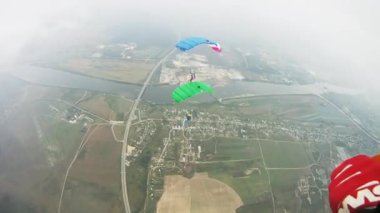 Yeşil alan üzerinde uçan renkli paraşüt ile skydivers. Aşırı aktif spor