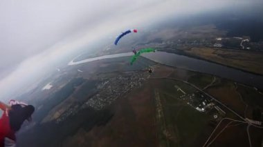 Yeşil alan üzerinde gökyüzü dengede renkli paraşüt ile skydivers. Tandem.