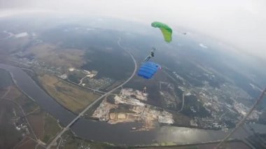 Gökyüzünde yeşil alan üzerinde paraşütle atlama skydivers. Aşırı. Bulutlu akşam.