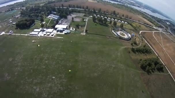 Parašutista létání nad zelené pole. Okamžik přistání. Extrémní aktivní sport. — Stock video