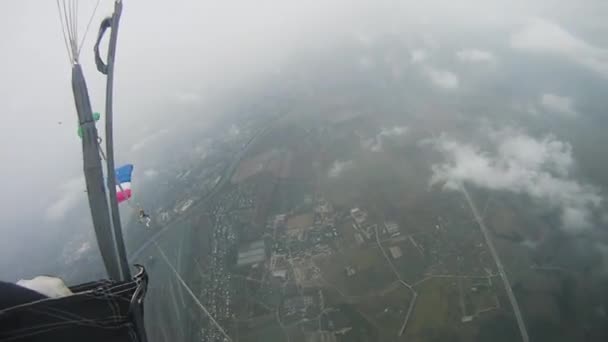 Os mergulhadores voam sobre o campo verde no céu. Nuvens. Desporto ativo extremo. Adrenalina . — Vídeo de Stock