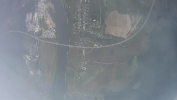 parachutiste parachutiste ouvert dans le ciel. Envolez-vous dans les nuages au-dessus du champ vert. Extrême .