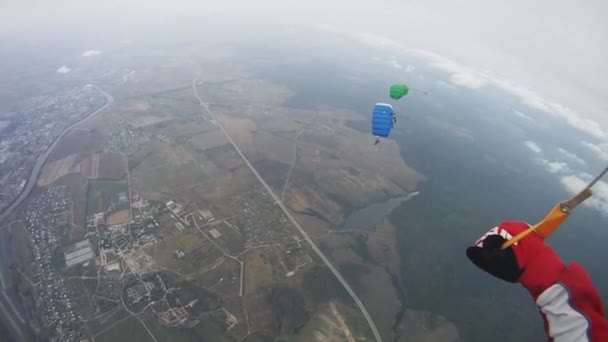 Skydiver pára-quedista no céu sobre o campo verde. Extremo. Noite nublada. Grupo — Vídeo de Stock