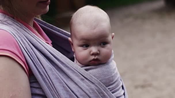 Jeune mère tenir bébé mignon en fronde sur l'aire de jeux. Jour d'été. Embrasse. L'amour — Video