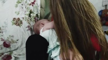 Kırmızı gömlek emzirme anne bebek divan. Annelik. Sağlık.