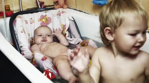 Il bambino gioca con i giocattoli di pesce nella vasca da bagno. Il bambino nuota nella culla. L'infanzia. Bambini. — Video Stock