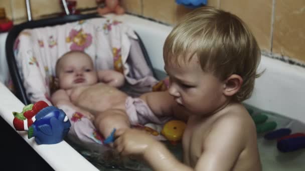 Kleine jongen spelen met vis speelgoed in bad. Baby zwemmen in de wieg. Geluk. Kinderen — Stockvideo