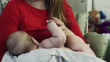 Genç anne'kırmızı gömlek de anne sütü küçük bebek divan. Annelik. Aşk