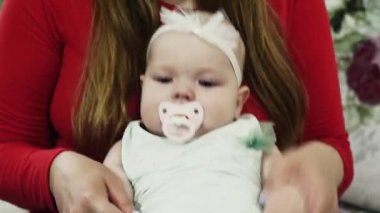 Kırmızı gömlekli genç anne ile bebek kanepenin üzerinde oynamak. Bebek kukla. Aşk