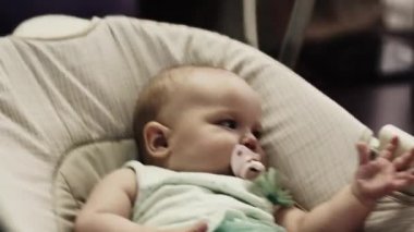 Küçük bebek salıncak daire üzerinde sway. Bebek kukla. El hareketleri
