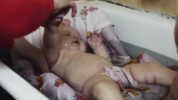 Kleiner Junge spielt mit Spielzeug in der Badewanne. Babyschwimmen in der Wiege. Mutter. Kindheit — Stockvideo