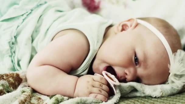 Entzückende kleine Baby auf dem Sofa liegen versuchen, Baby-Attrappe zu nehmen. Niedlich. Weinen. Tränen. Kind — Stockvideo