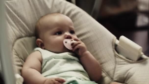 Entzückendes kleines Baby wiegt sich auf der Schaukel. Babyattrappe. Kind. zu Hause. Wohnung. Mädchen — Stockvideo