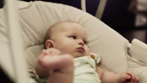 Adorable little baby sway on swing in apartment. Raise leg. Child. Home. — Stock Video