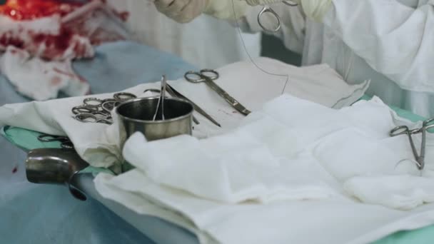 外科医は、女性の胃の中を縫う針と糸を準備します。帝王. — ストック動画