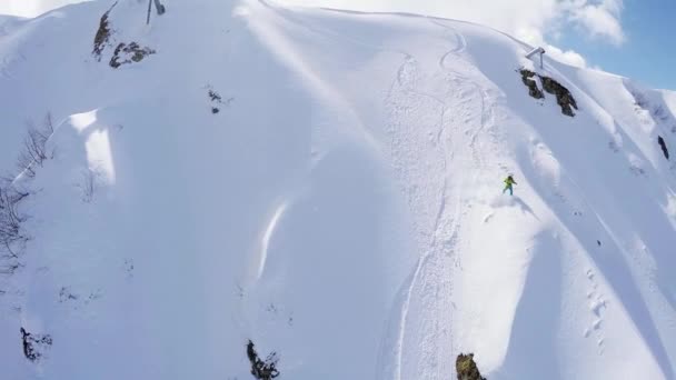 Quadrocopter sparare snowboarder giro gratuito dalla cima della montagna innevata. Estremo — Video Stock