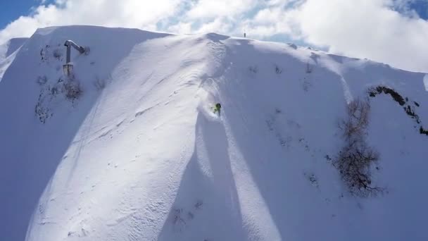 Quadrocopter shoot snowboarder free ride from peak of snowy mountain. Powder — Stock Video