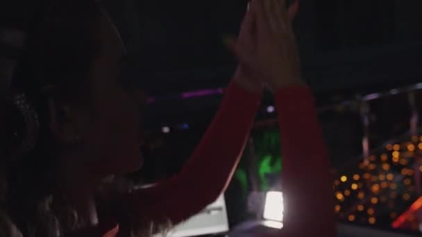 Dj chica en vestido rojo aplauden en las manos en el tocadiscos en la fiesta en el club nocturno. Foco — Vídeo de stock