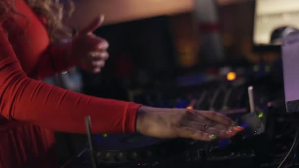 Menina DJ em vestido vermelho girando na plataforma giratória em festa na boate. Desempenho — Vídeo de Stock