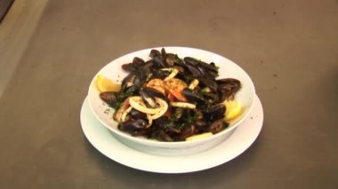 Beyaz şarap limon, karides ve fesleğen ile hazırlanan midye beyaz plakalı. Taze restoran yemek.