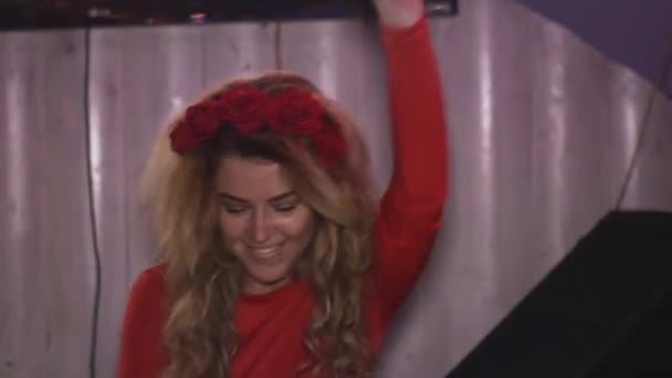 Menina DJ em vestido vermelho girando na plataforma giratória na boate. Desempenho. Mãos no ar — Vídeo de Stock