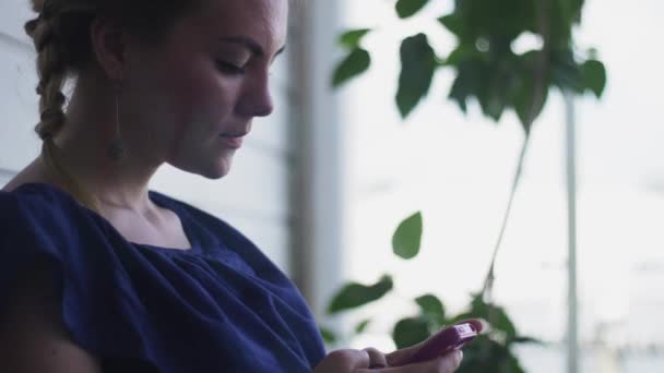 Žena v modrých šatech, boty na podpatku boty sedět na terase restaurace stáčení telefonu — Stock video